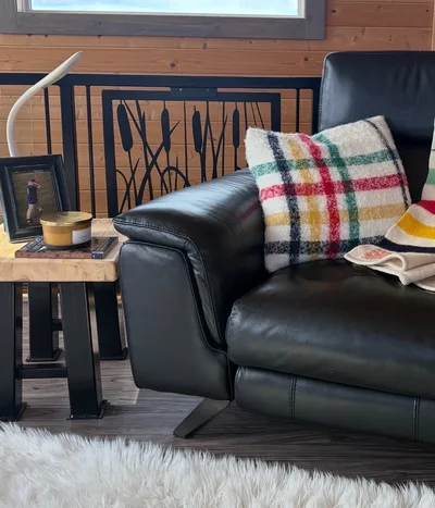 Finished timber interior with black railing, leather chair, wood walls, and dark plank flooring